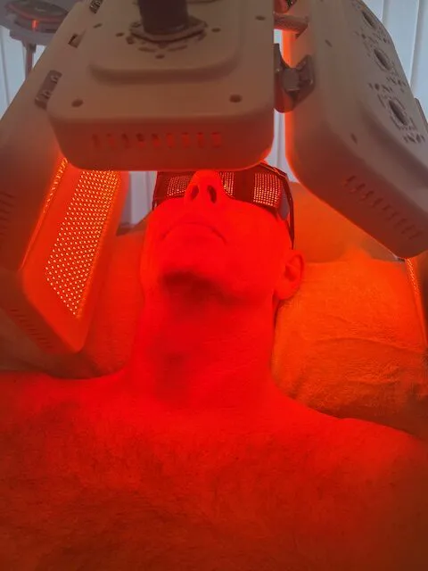 Patient modtager LED-lysterapi med roedt lys i ansigtet